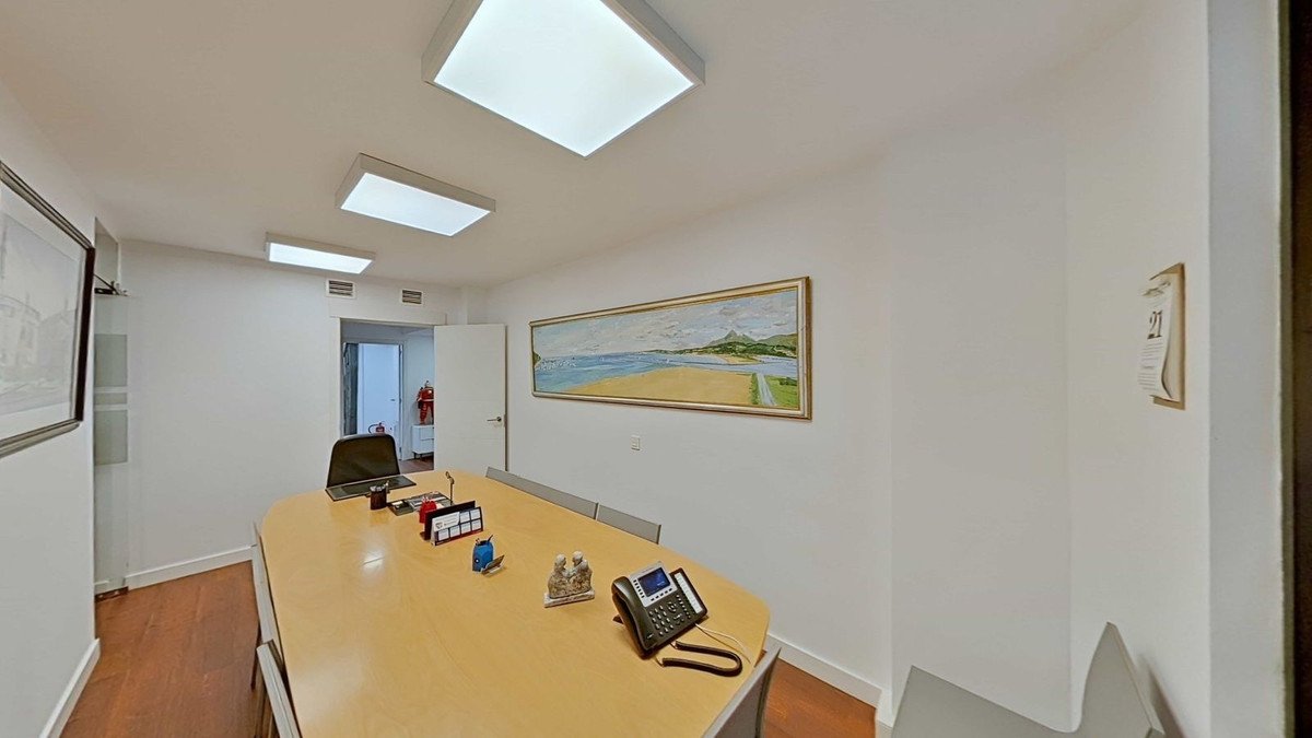 A conference room with a meeting table, artwork on the wall, and a phone, indicating a professional office space.