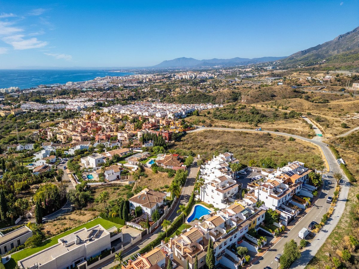 Aerial view of coastal luxury homes with ocean and distant mountains in the background