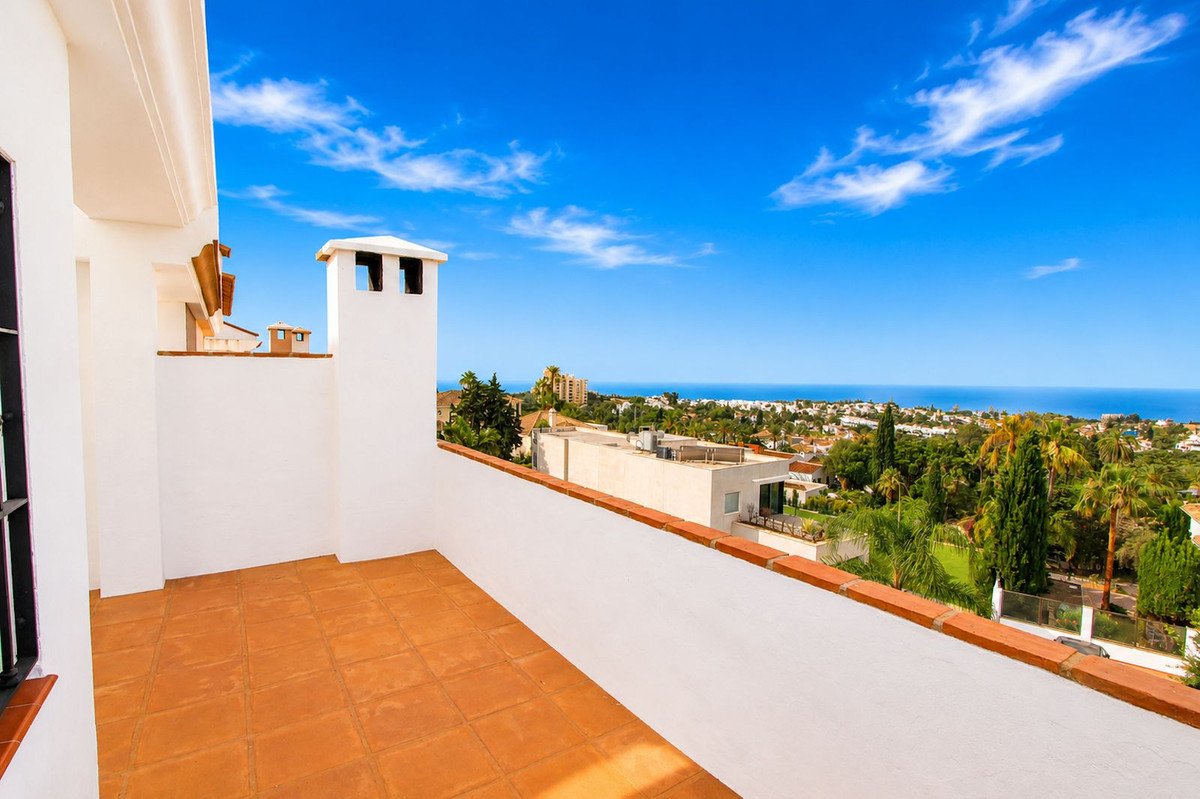 Balcony with white walls and terracotta tiles overlooking the sea