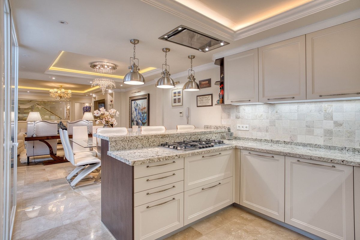 Modern kitchen with marble countertops and dining area view