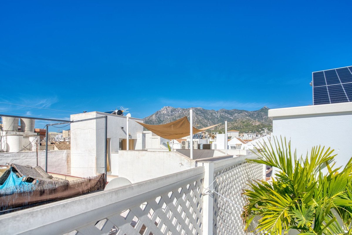 White rooftop terrace with solar panels and mountain view