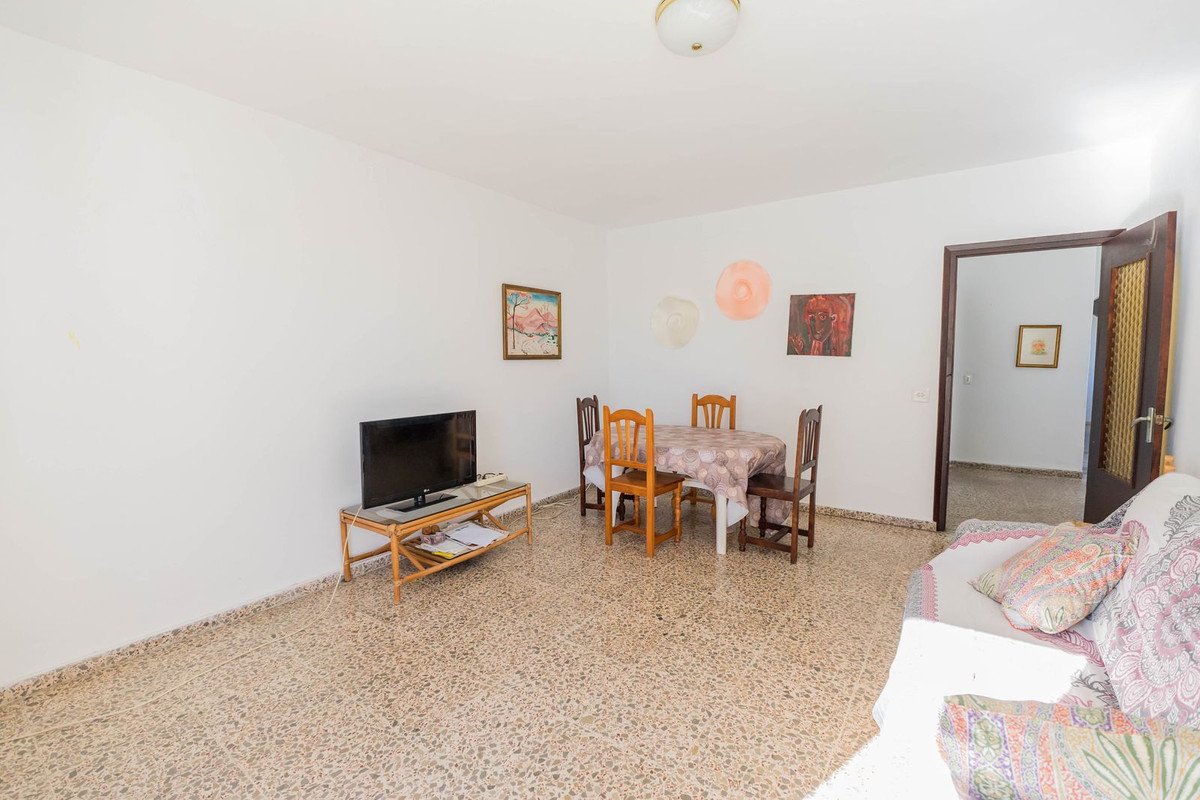 Living room with TV, dining table, and colorful wall decorations