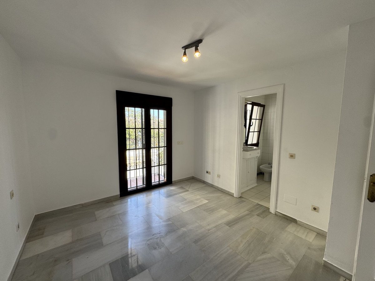 Empty living room with large windows and view to the bathroom