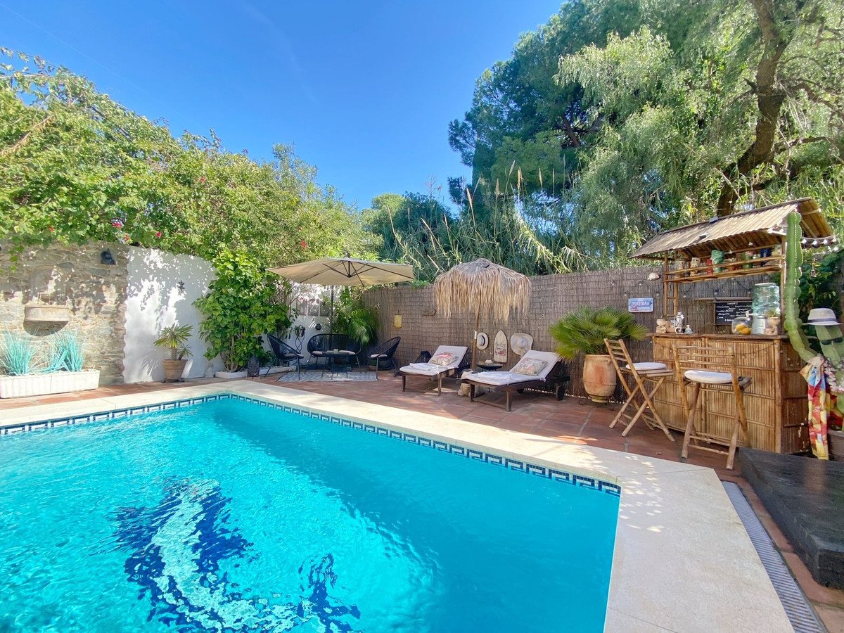 Luxurious swimming pool with bar and relaxing lounge area surrounded by greenery