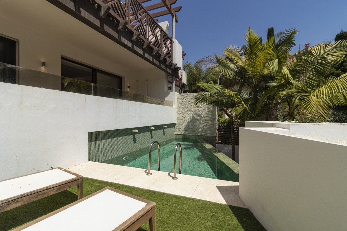 Modern swimming pool with palm trees and a white building