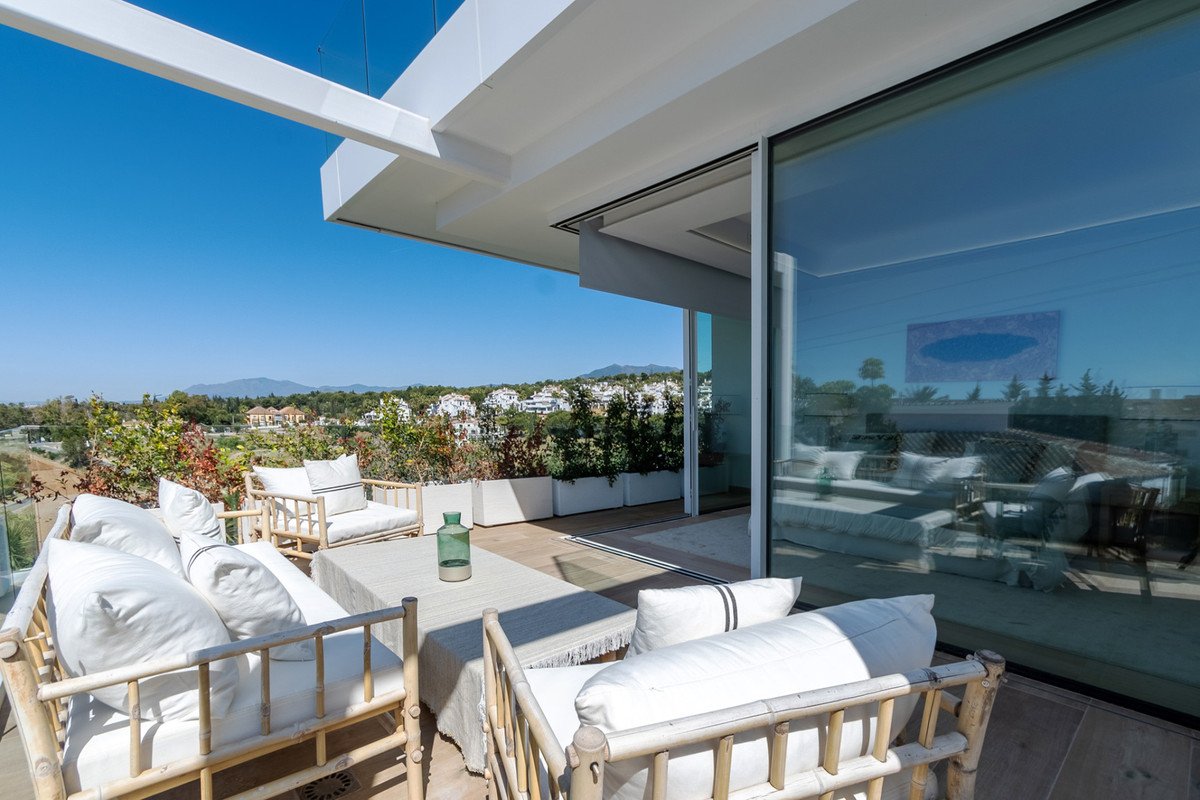 Modern outdoor lounge with white furniture and scenic sea view