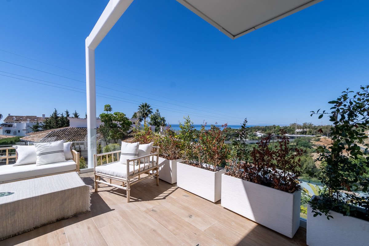 Balcony with seating area, plants, and scenic ocean view