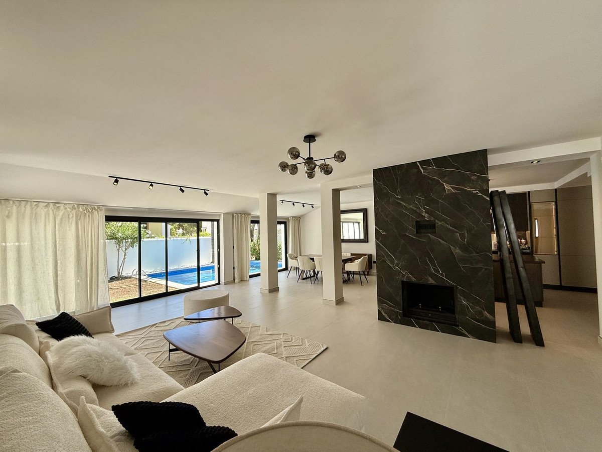Modern living room with large windows overlooking a swimming pool