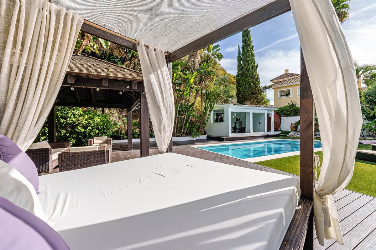 Luxury bedroom with outdoor view of swimming pool and garden