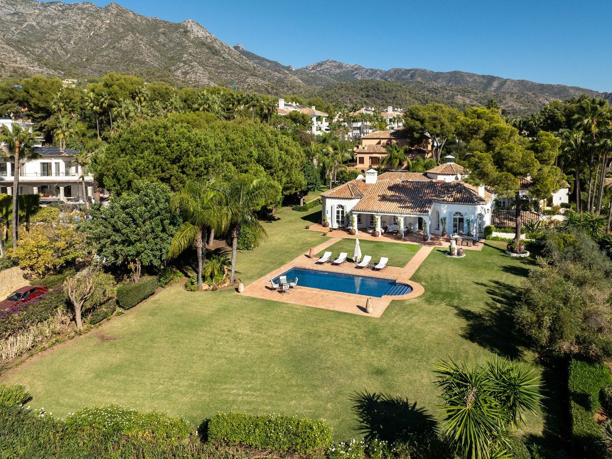Luxurious swimming pool surrounded by lush garden and mountains