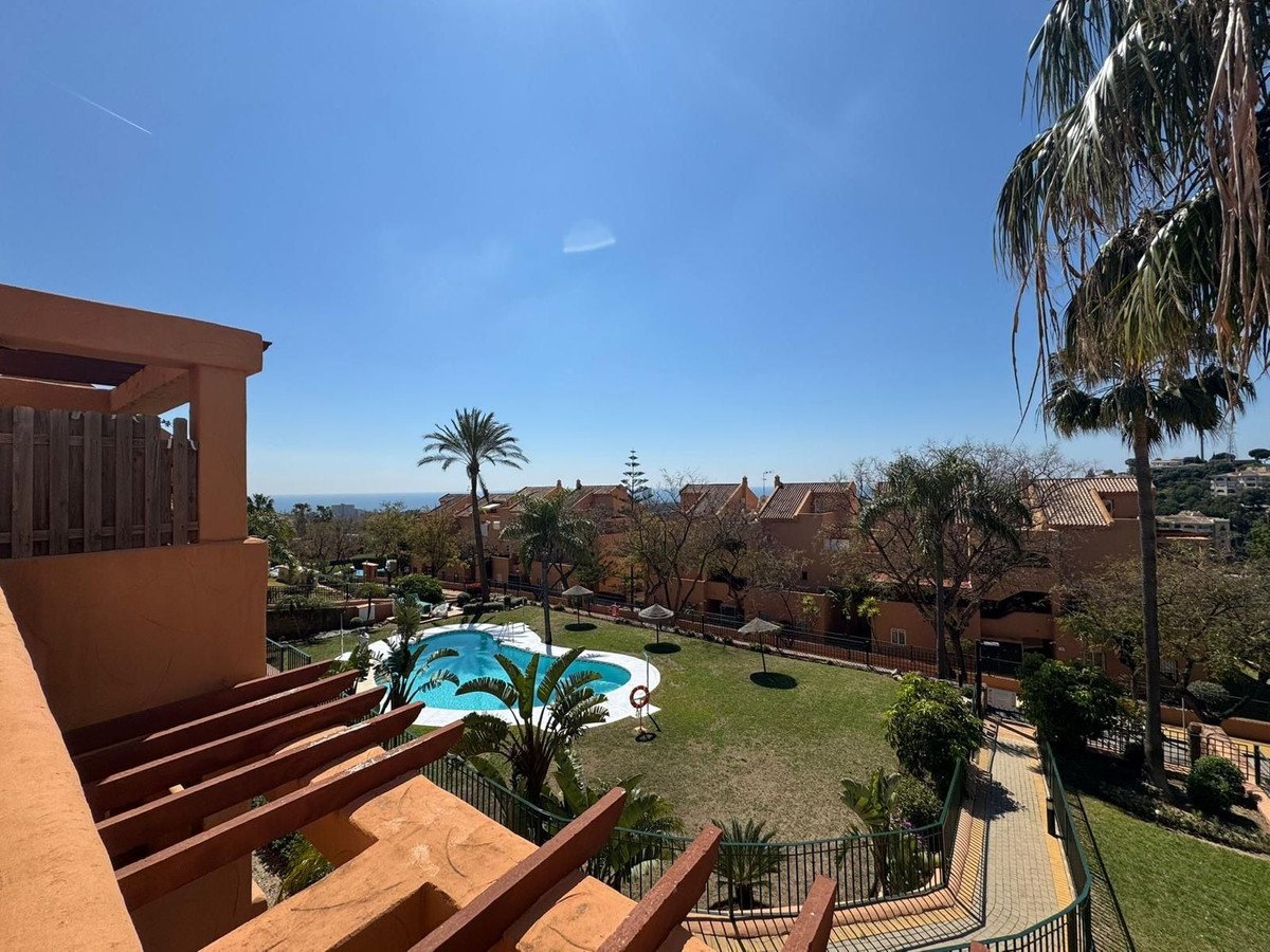 Apartment balcony overlooking a community pool and palm trees