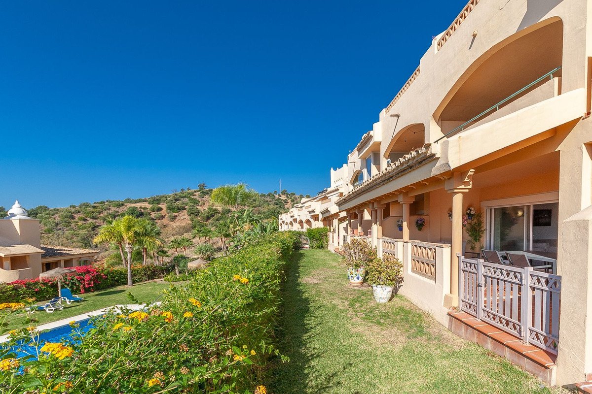 Apartment with outdoor pool, garden, and mountain view under blue sky