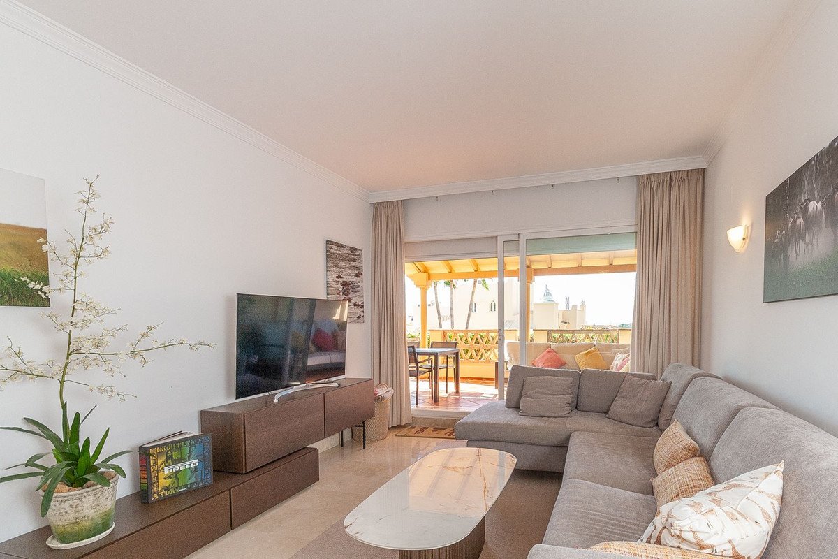 Spacious living room with grey sofa, TV, and sliding doors to outdoor patio