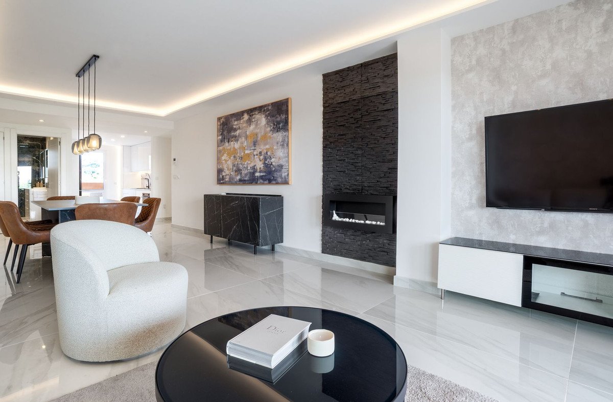 Modern living and dining room with a sleek fireplace, comfortable seating, and elegant decor.