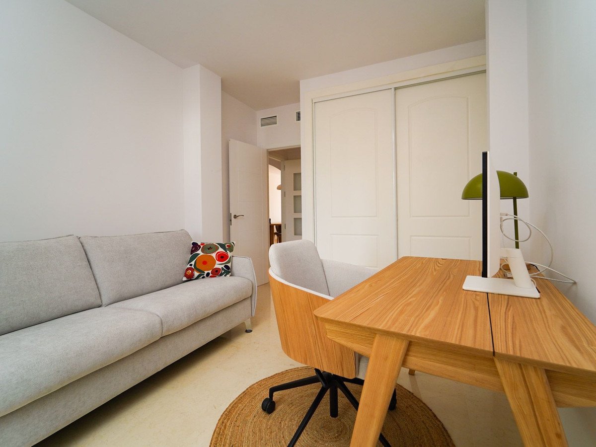 Living room with sofa, desk, chair, and sliding closet doors