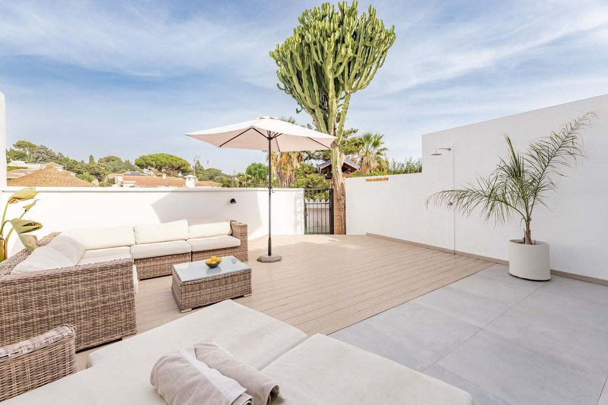 Spacious rooftop terrace with comfortable outdoor seating, sun loungers, and a large succulent plant.