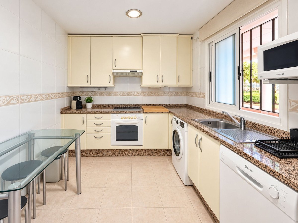 Modern kitchen with cream cabinets, granite countertops, and a window view