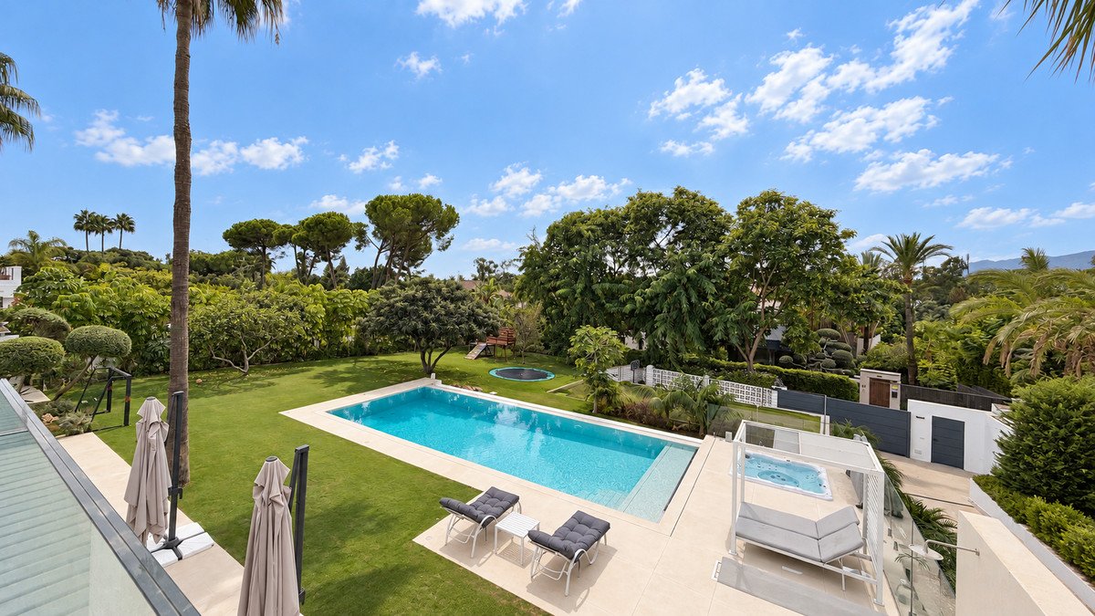 Backyard with swimming pool, lounge chairs, and outdoor seating area