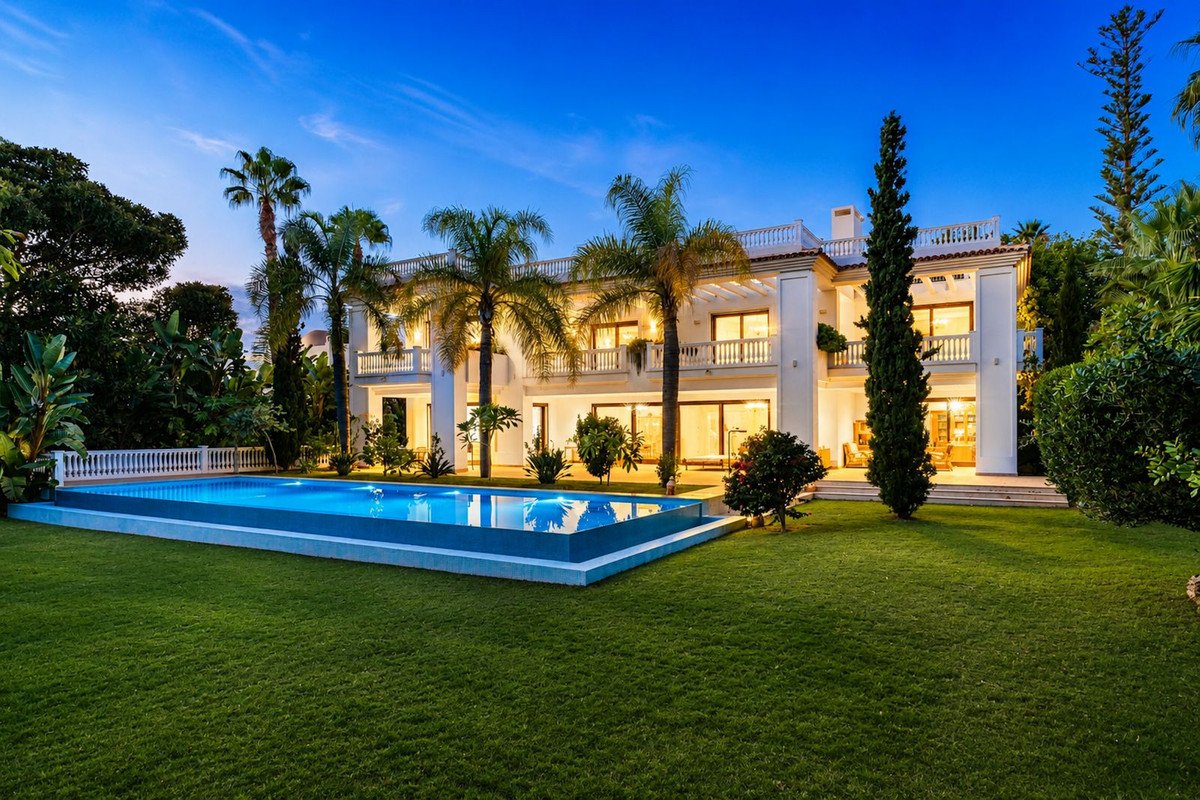 Luxury villa with swimming pool and manicured lawn at dusk