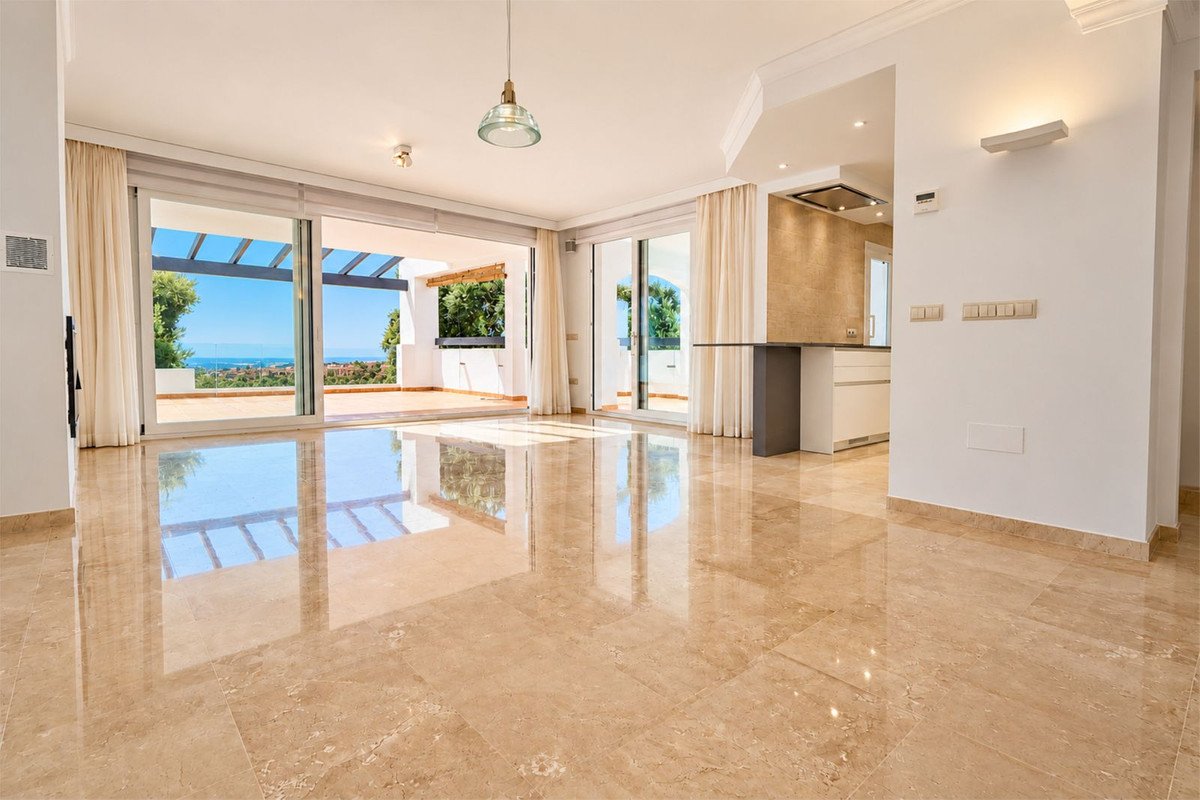 Spacious living room with marble floors, large windows opening to a terrace with a sea view and an adjacent kitchenette.