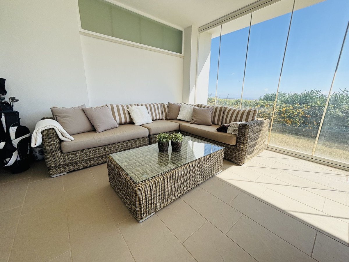 Outdoor lounge with wicker furniture and sea view through large windows