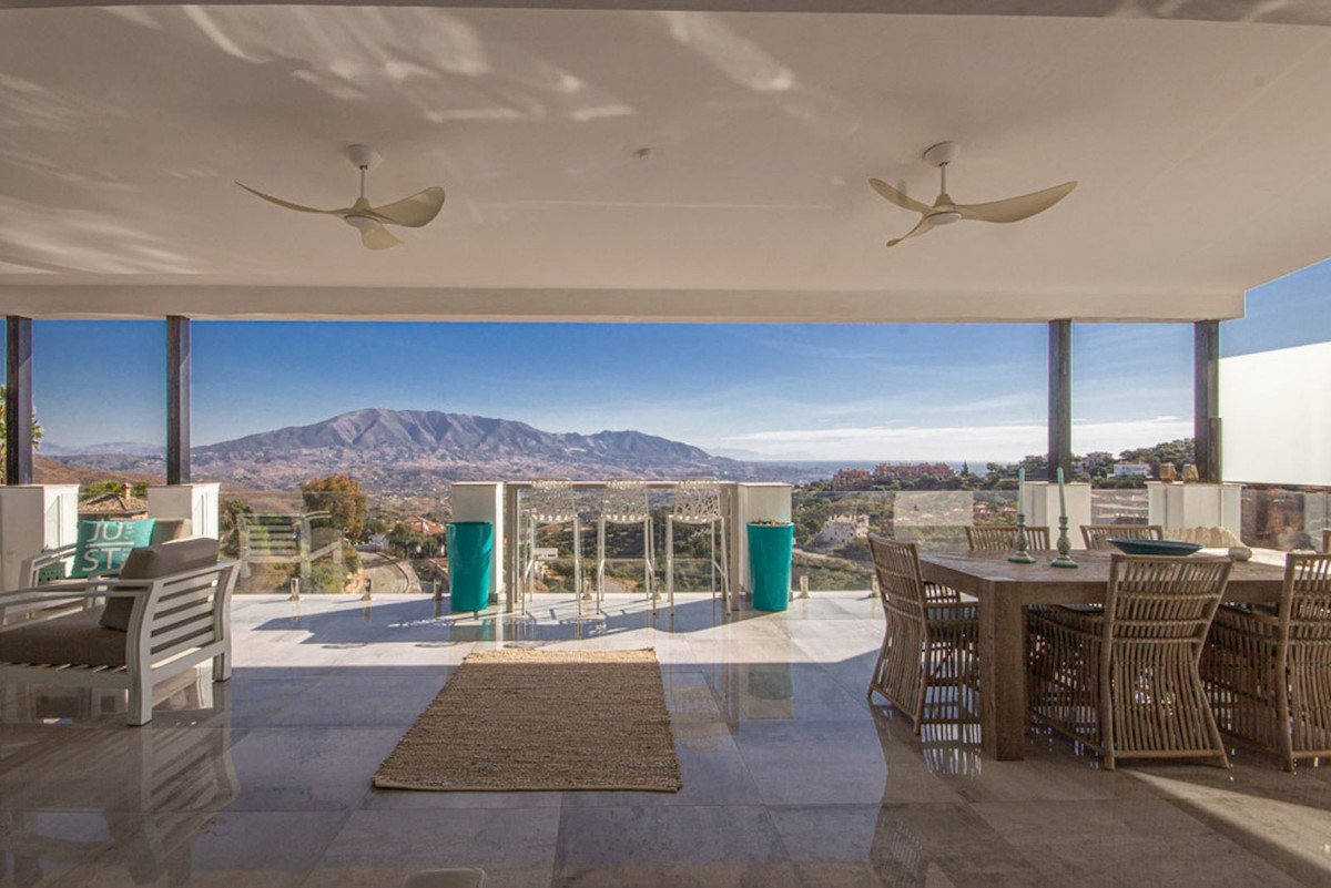 Covered patio with dining area, bar seating, and a breathtaking mountain and valley view.