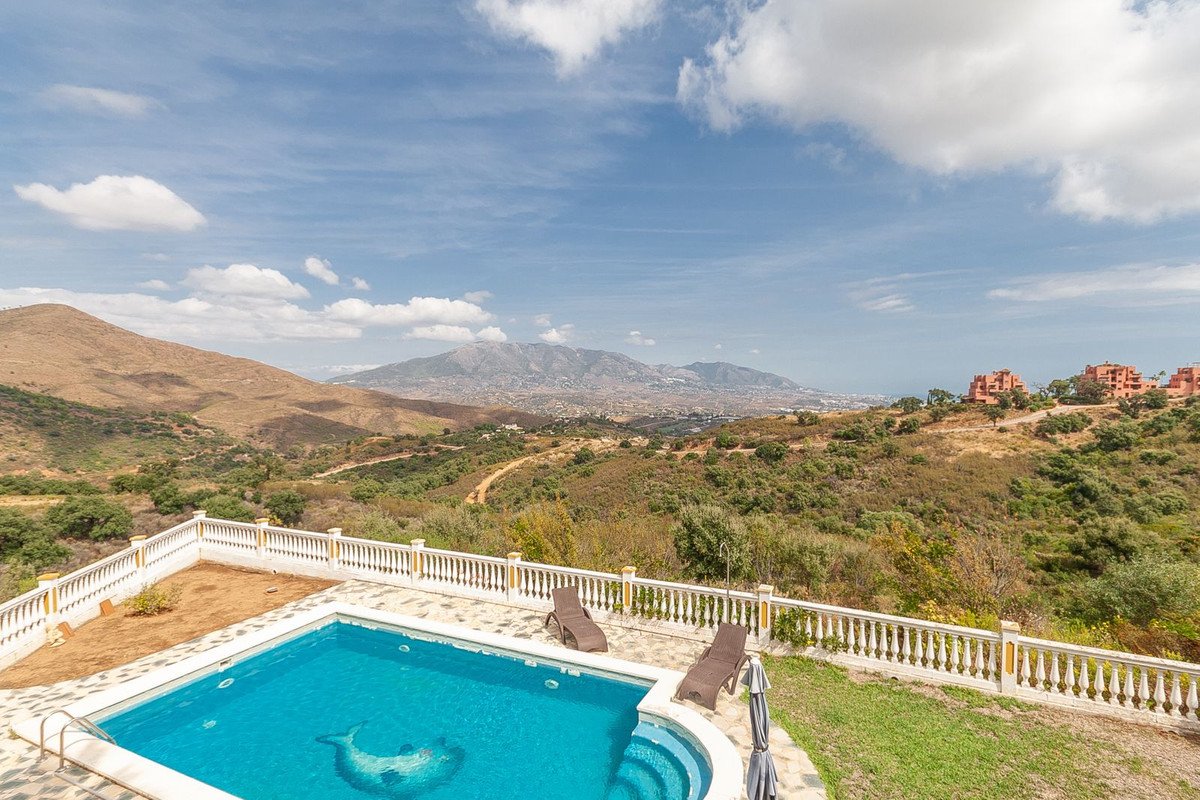 Private swimming pool with sun loungers and a stunning panoramic mountain and coastal view.