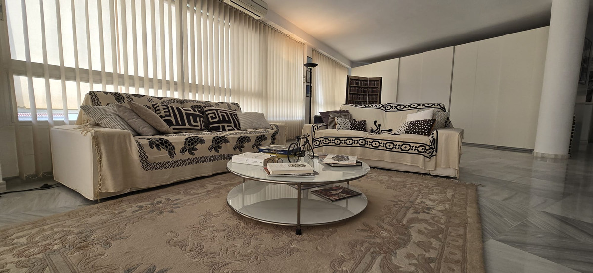 Gezellige woonkamer met comfortabele banken en een ronde salontafel.