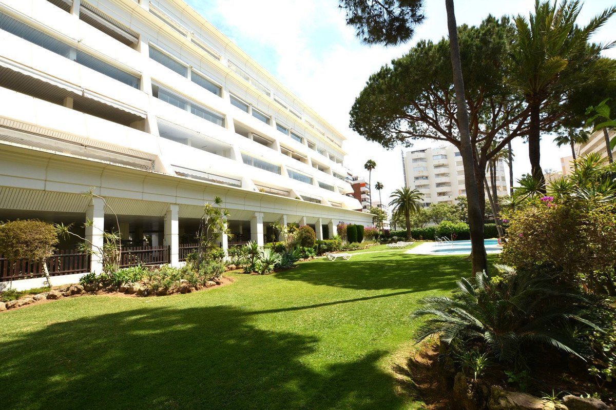 Modern apartment complex with lush green lawn and swimming pool