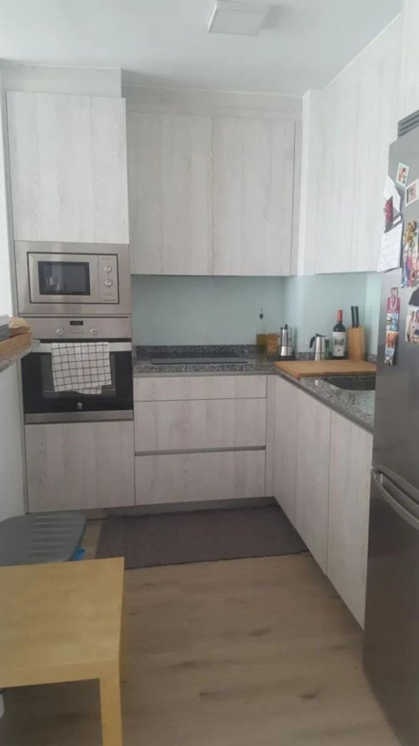 Modern kitchen with light wood cabinets, stainless steel appliances, and granite countertops