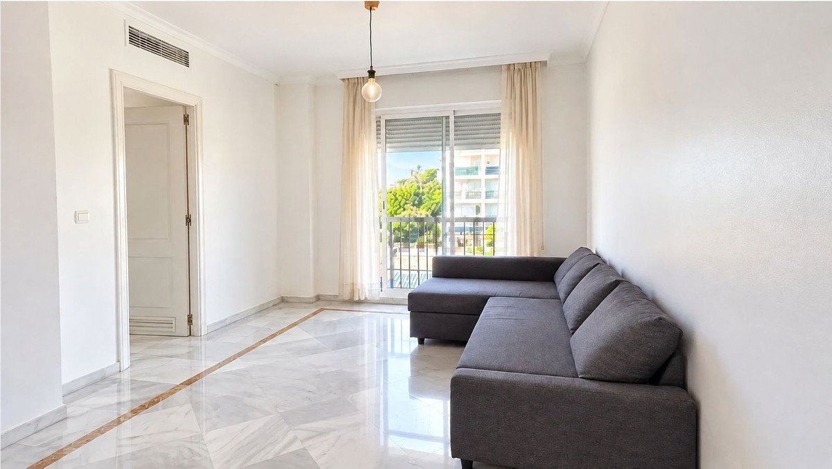 Bright living room with grey sofa, marble floor, and balcony view