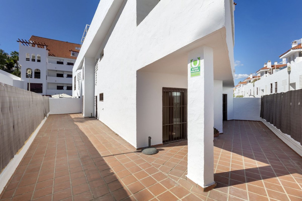 White building with tiled terrace and patio, sunny outdoor space