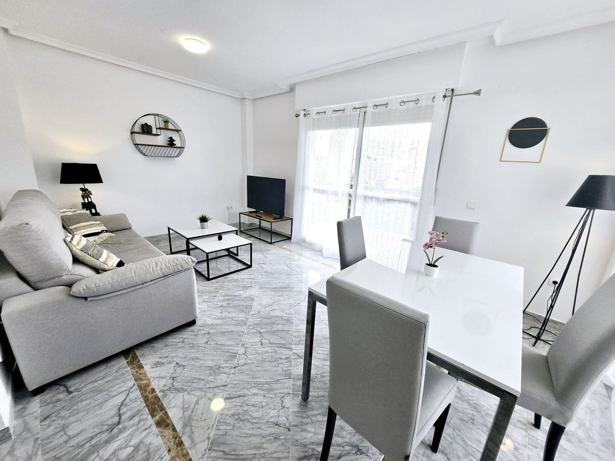 Modern living and dining room with marble flooring, sofa, and large windows