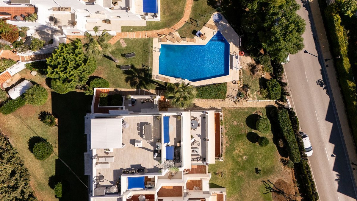 Aerial view of a luxury villa with a swimming pool and outdoor spaces