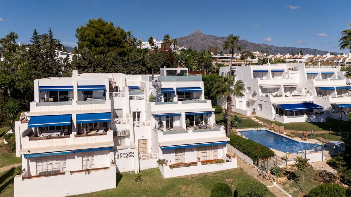 White apartment complex with swimming pool and mountain view