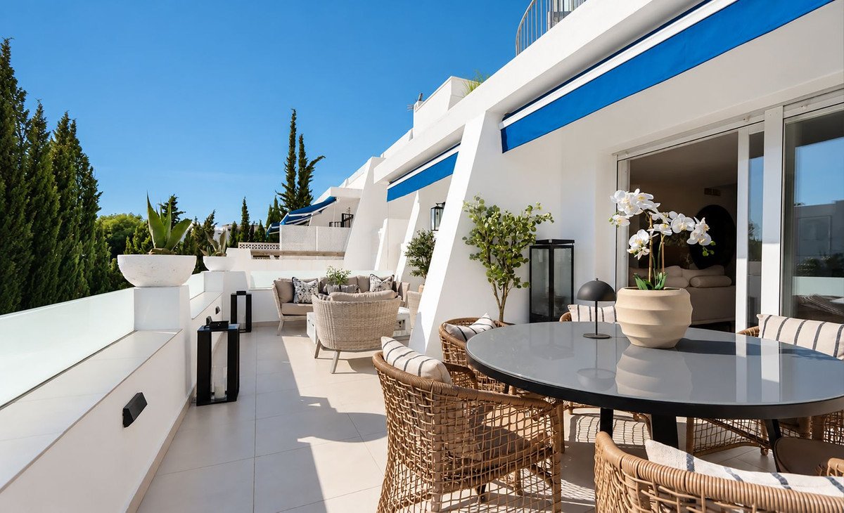 Modern rooftop terrace with wicker dining furniture and outdoor seating area