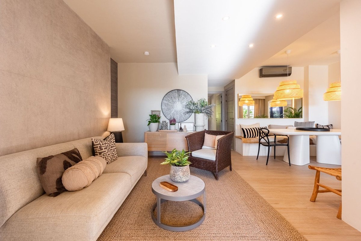 Modern living and dining area with a sectional sofa, accent chair, dining table, and natural light.