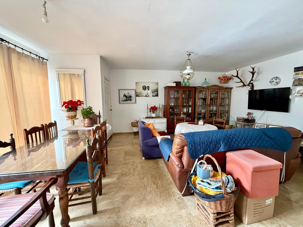 Spacious living and dining area with wooden furniture, comfortable seating, and decorative items visible.