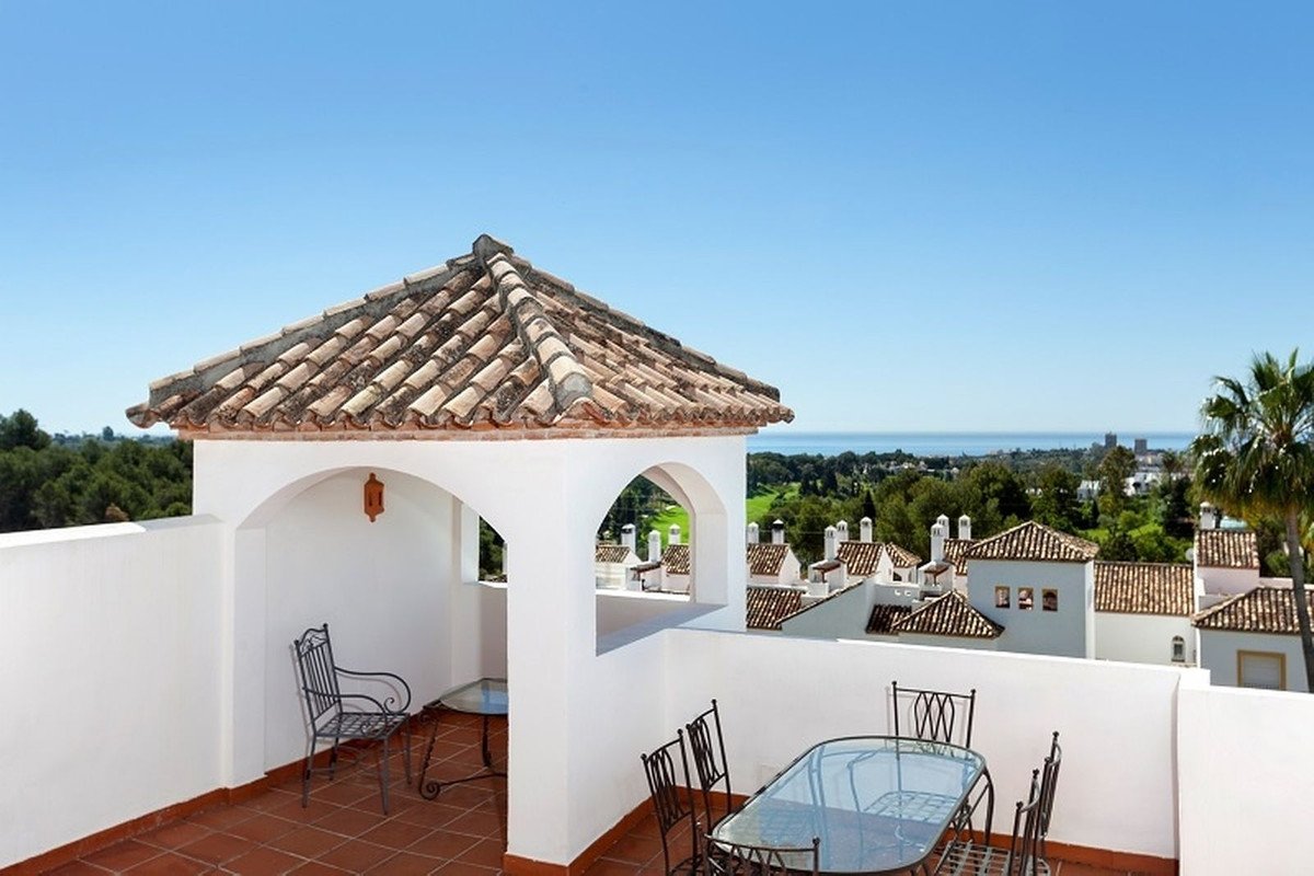 Rooftop terrace with patio furniture, sea view, and white walls