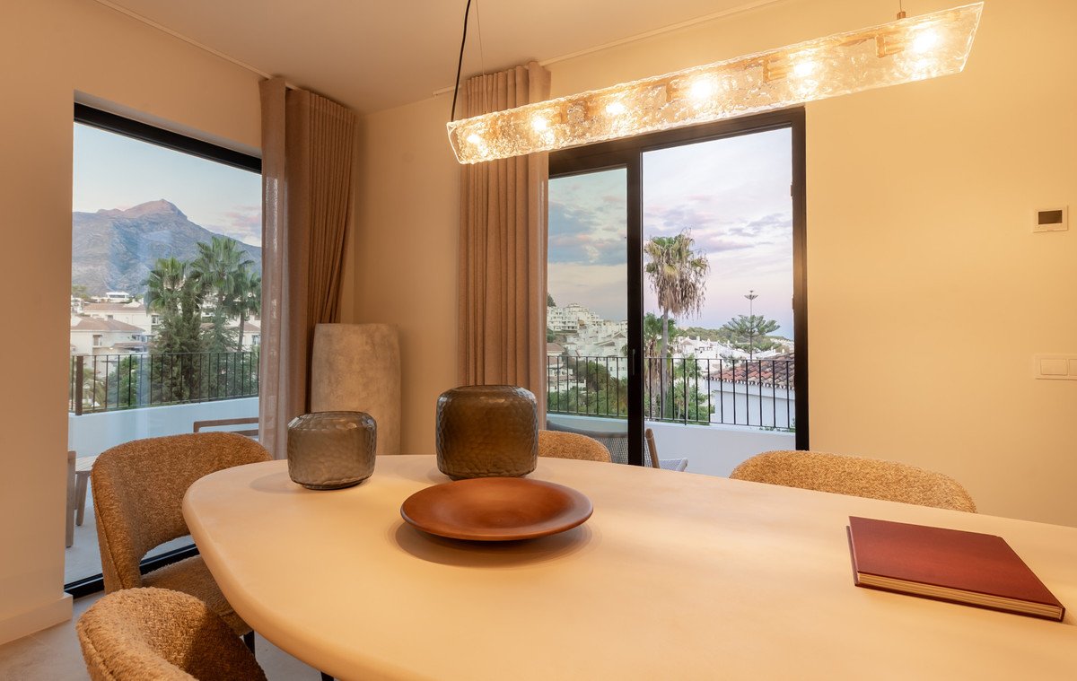 Modern dining room with mountain and palm tree views through large windows