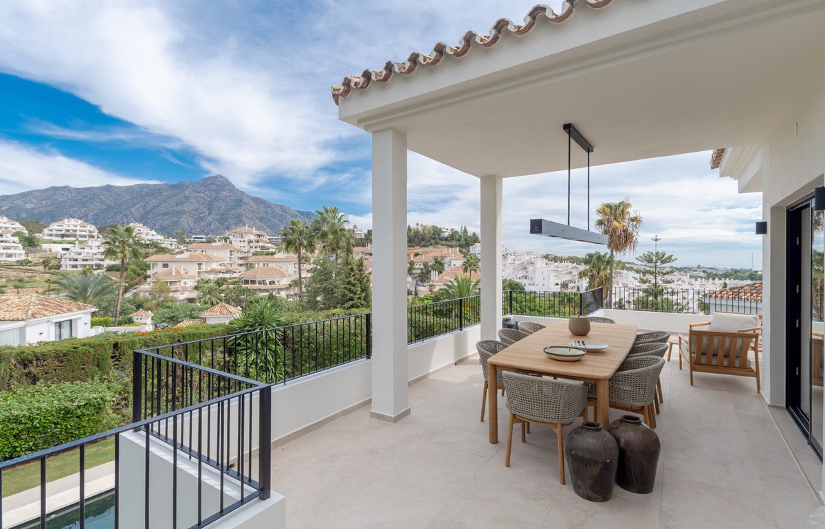 Modern patio with dining table and chairs overlooking mountain and town views