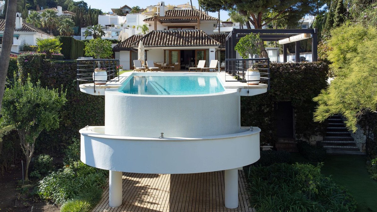 Luxurious outdoor swimming pool with a scenic view of surrounding houses and greenery