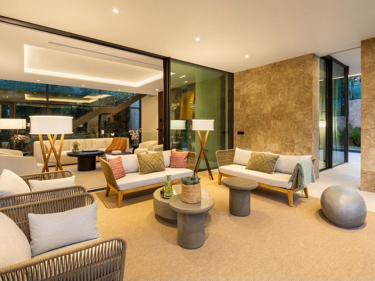 Modern living room with beige sofas, wooden tables, and large floor lamps