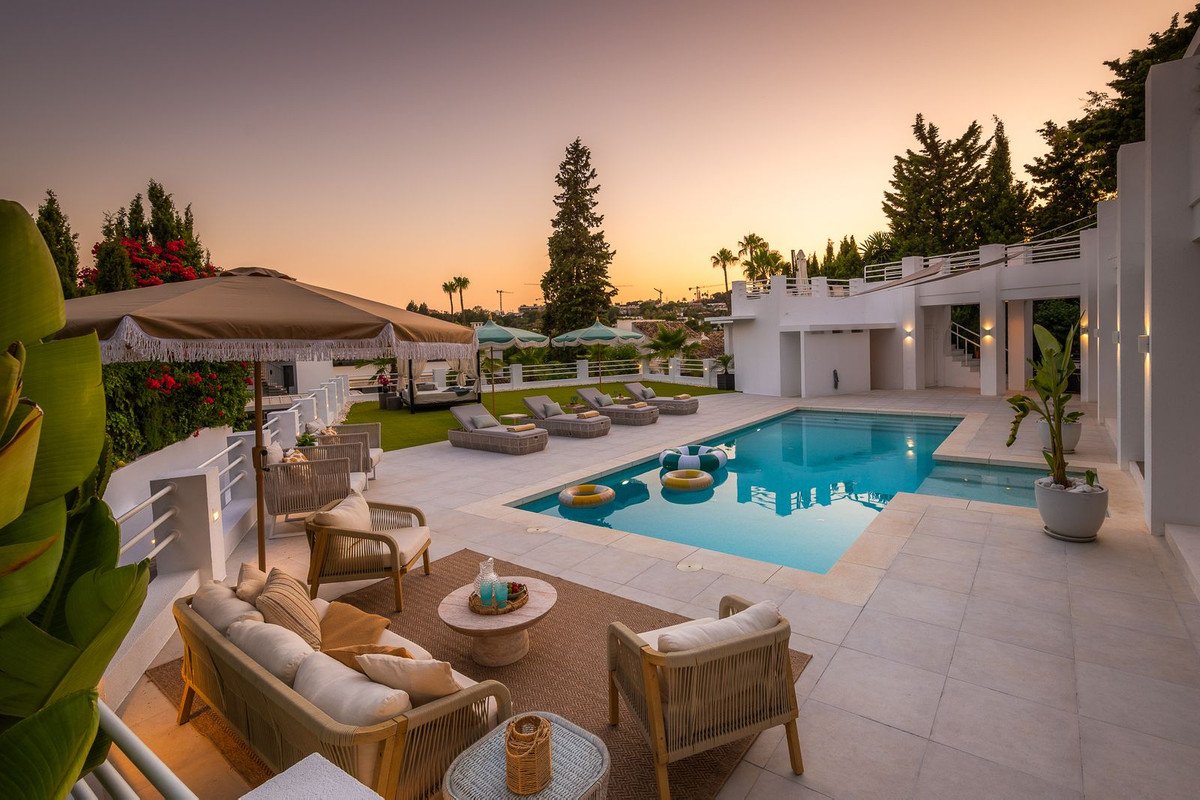 Outdoor pool area with lounge seating and sunset view