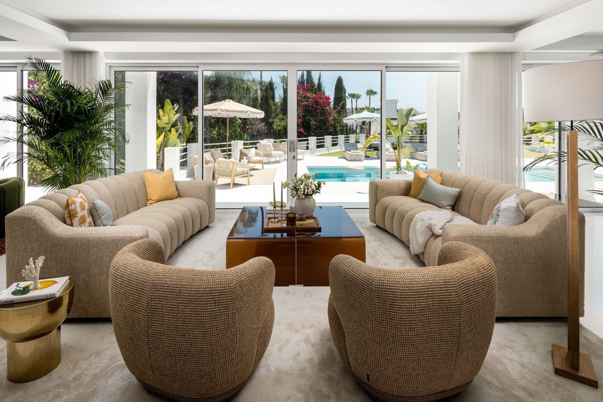Modern living room with pool view, large windows, and comfortable seating