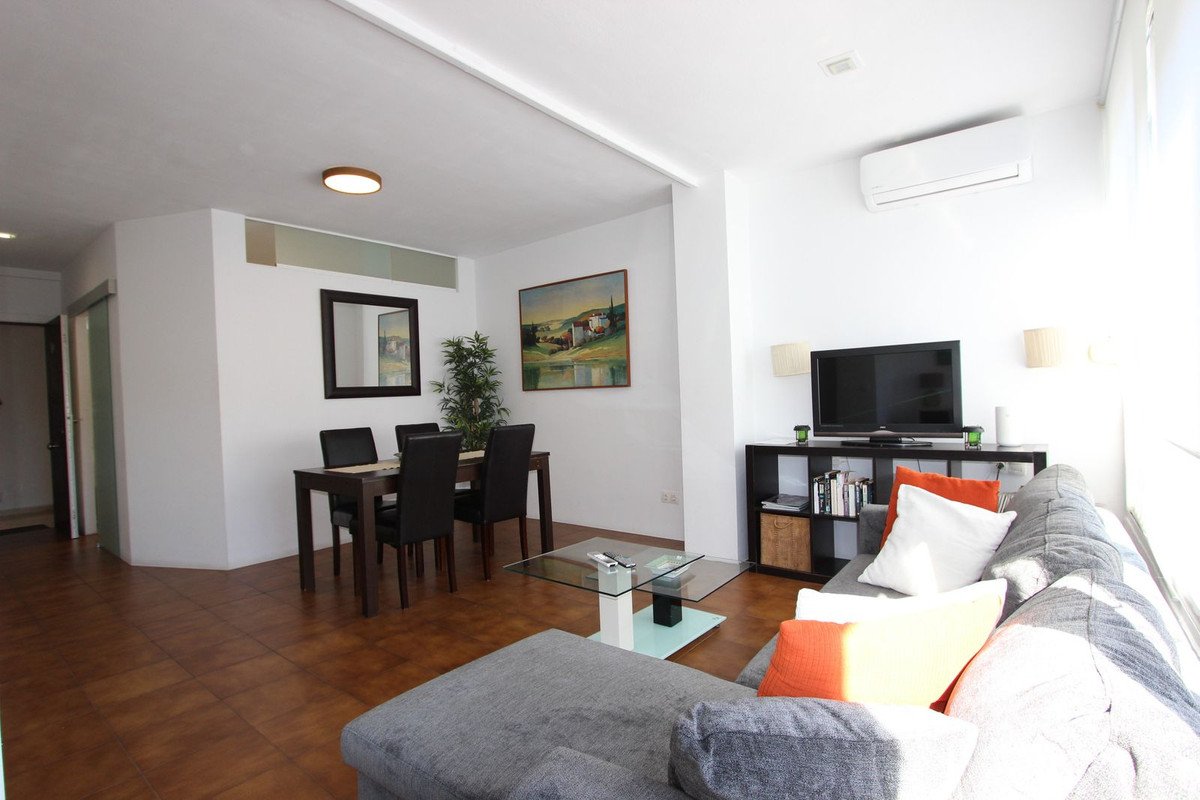 Open-plan living and dining room with sofa, TV, and dining table
