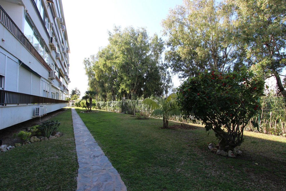 Apartment building with garden path and trees