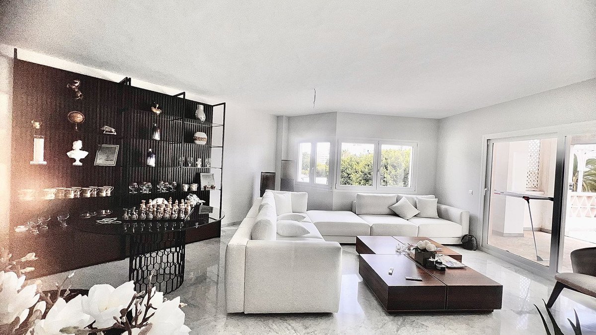 Modern living room with white sofa, large windows, and sliding doors to outdoor space