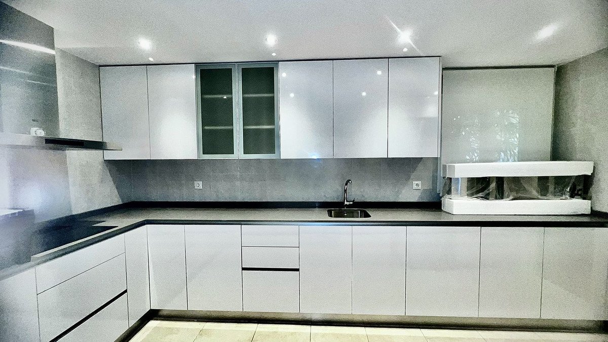 Modern kitchen with white cabinets, dark countertops, and a sink.