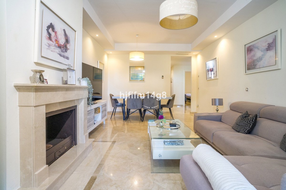 Modern living and dining room with a fireplace, sofa, dining table, and elegant decor.